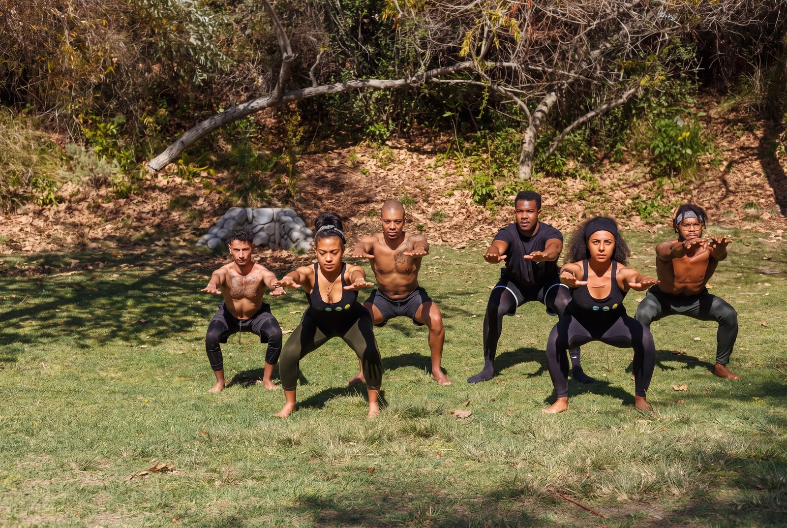 Group performing squats during an outdoor movement training session