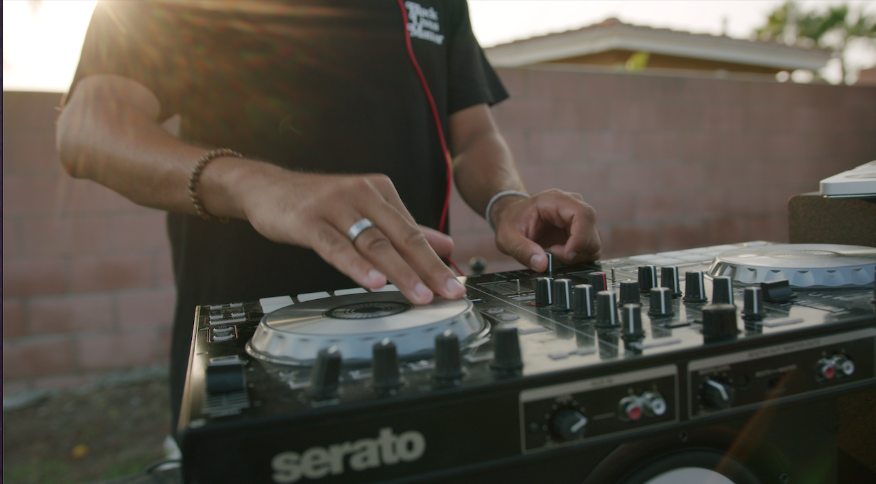 DJ mixing on a Serato controller outdoors