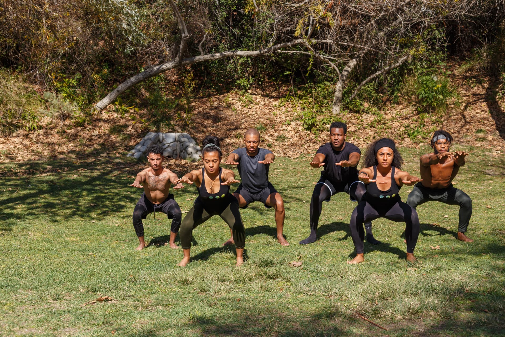 Group performing squats during an outdoor movement training session